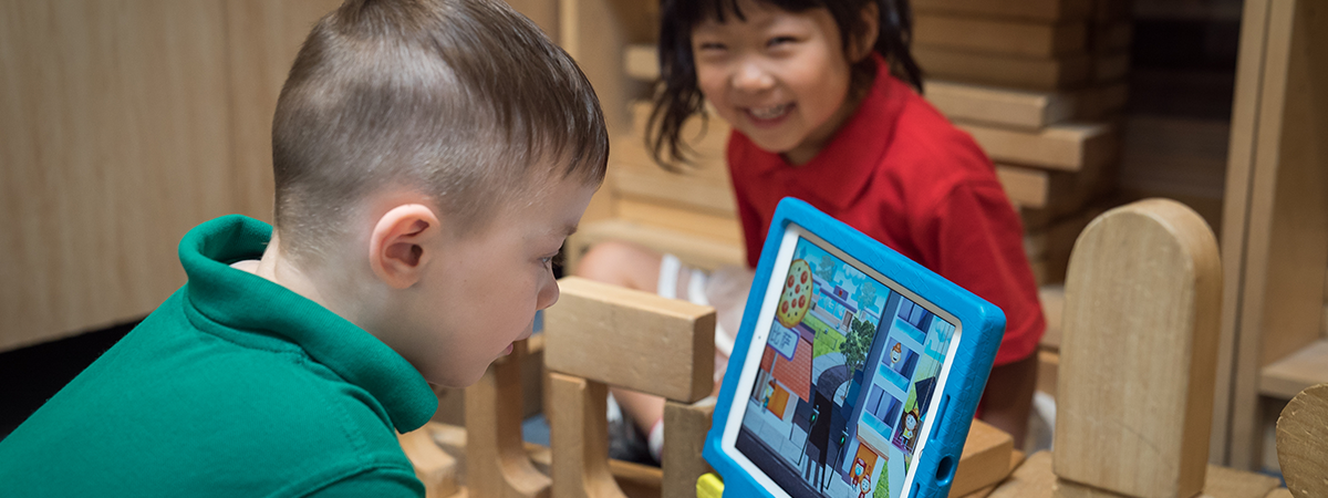 Child uses ELLA app on tablet in a kindergarten setting.
